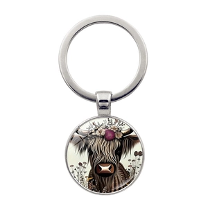 Detail showing highland cow illustration with flower crown on a silver keychain