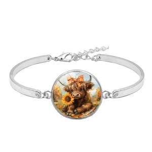 Detailed macro view of Highland Cow charm bracelet with sunflower and plaid bow detail