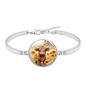 Detailed macro view of Highland Cow and sunflower pendant on silver charm bracelet