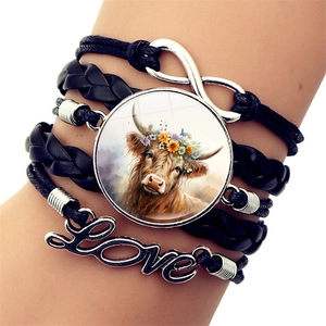 Makroaufnahme von mehrschichtigem Hochlandkuh-Armband mit Liebesanhängern und Unendlichkeitssymbol
