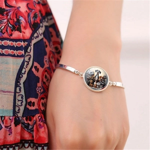 Pulsera plateada con colgante circular de fotos de perros en la muñeca de una persona