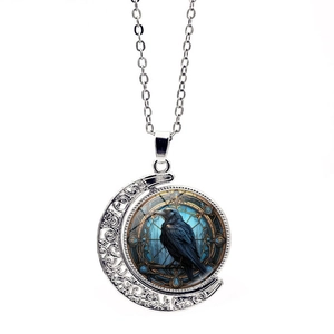 Gothic rotating moon necklace with black raven and blue stained glass patterns