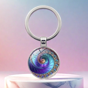Detail view of Fibonacci spiral keychain with purple fractal pattern on white marble stand