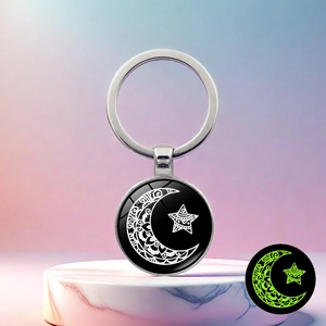 Luminous keychain featuring sun and moon pattern with green glow effect in the dark
