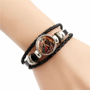 Detail of multi-layer leather bracelet featuring St. Michael glass cabochon charm
