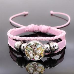 Dettaglio del bracciale multistrato in pelle rosa con ciondolo in vetro con gatti