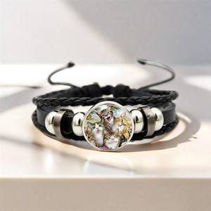 Dettaglio del bracciale in pelle intrecciata multistrato con ciondolo gatto in vetro