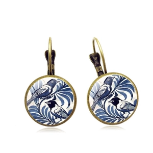 Detail of vintage silver leverback earrings featuring blue bird pattern art under glass