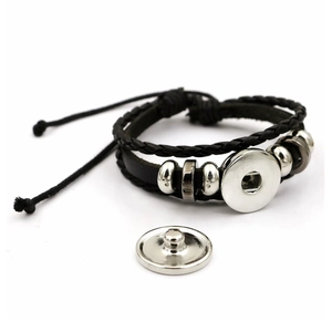 Dettaglio del bracciale in pelle nera intrecciata a doppio strato con base a scatto
