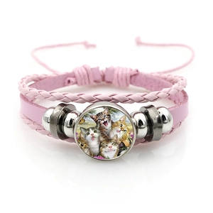 Dettaglio del bracciale multistrato in pelle rosa con motivo gatto e cabochon in vetro