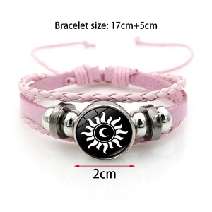Detailed view of pink leather woven bracelet with sun and moon glass gem charm