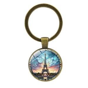 Vintage bronze Eiffel Tower keychain with artistic colorful glass illustration on white background