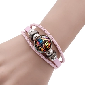 Close-up of pink layered leather bracelet with Bigfoot forest sunset charm and metal beads