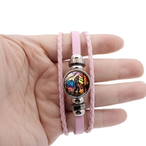 Detail of pink multilayer braided leather bracelet featuring a Bigfoot forest sunset charm