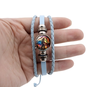 Detail of multi-layer leather bracelet featuring a Bigfoot pendant with forest sunset pattern