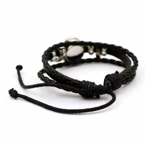 Détail du bracelet tressé en cuir noir avec des ornements en métal sur le thème du football