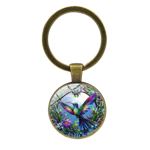 Retro bronze hummingbird glass gem keychain with colorful floral art on white background