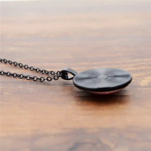 Close-up of the vintage bronze pendant back featuring a textured sunburst metal pattern