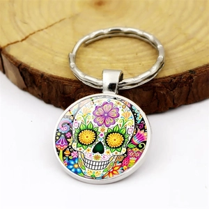 Mexican sugar skull keychain with colorful floral patterns and polished metal ring