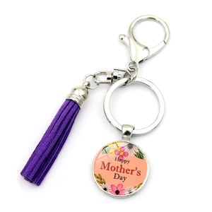 Detail of a Mother's Day keychain with a purple suede tassel and a floral glass pendant