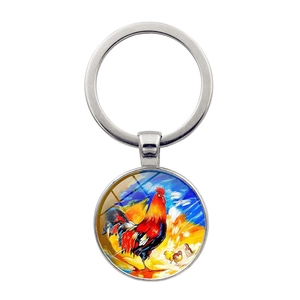 Vue détaillée d'un porte-clés rond en métal avec illustration de coq au style peinture à l'huile