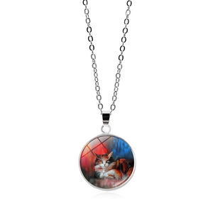 Détail macro du pendentif rond en verre montrant le design artistique du chat calicot