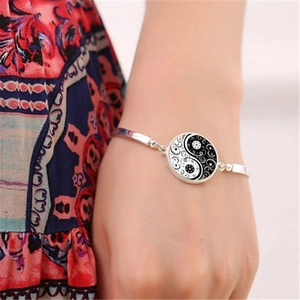 Détail d'un bracelet argenté orné d'un pendentif yin yang aux motifs cachemire