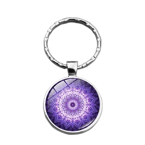 Close-up of deep purple mandala pattern keychain with glossy glass cabochon finish