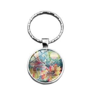 Detailed view of silver hummingbird glass cabochon pendant on a metal keychain ring