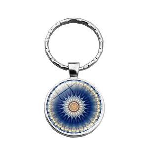 Close-up of silver mandala keychain with a blue geometric glass cabochon pendant