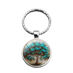 Close-up of glass dome keyring with artistic tree of life pattern and silver metal frame