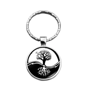 Macro detail of silver Tree of Life glass cabochon pendant on metal keychain ring