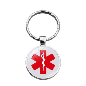 Gros plan détaillé d'un porte-clés médical en argent avec le symbole de vie rouge