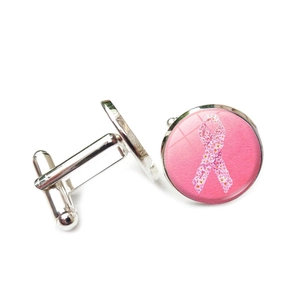 Detailansicht der silbernen runden Manschettenknöpfe mit dem Symbol der rosa Schleife für Männer