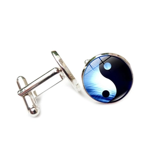 Macro detail of Yin Yang pattern glass stone cufflinks with polished silver finish