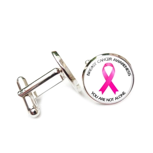 Detailansicht der silbernen Manschettenknöpfe mit rosa Schleife und Spendenaufdruck