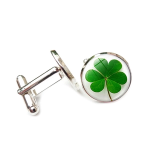 Détail macro de boutons de manchette trèfle argenté avec dôme en verre vert et fermoir T