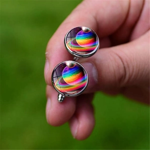 Macro view of men's shirt cufflinks featuring a colorful galaxy and Saturn design