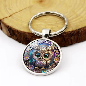 Artistic owl time gem keychain with silver metal ring on a natural wooden base