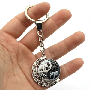 Rotating Yin Yang elephant moon keychain with double-sided silver crescent metal frame