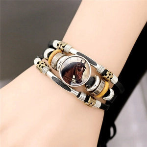 Détail d'un bracelet en cuir multicouche avec un cabochon en verre motif tête de cheval