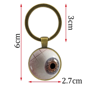 Porte-clés œil réaliste en métal bronze avec dimensions indiquées sur fond blanc neutre