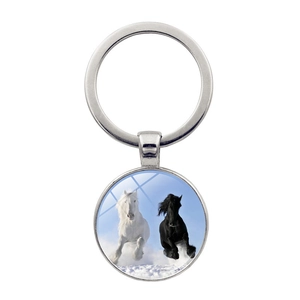 Macro shot of a silver horse pendant keychain showing two horses running on snow detail