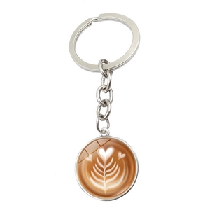 Detail of coffee latte art glass cabochon pendant on silver metal keychain