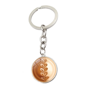 Detailed view of silver keychain featuring a round coffee latte art glass cabochon
