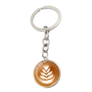 Detailed close-up of a coffee latte art glass gem keychain with silver metal plating