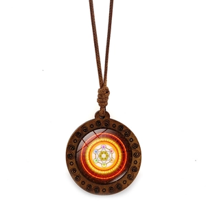 Détail du pendentif fleur de vie en bois avec géométrie sacrée et cordon en cire marron