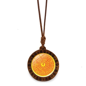 Détail du pendentif mandala fleur de vie en bois avec cordon tressé marron vintage
