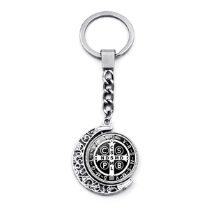 Macro detail of silver Saint Benedict medal keychain with moon-shaped hollow carving
