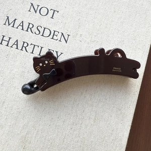 Detail of France Handmade logo on a glossy dark cat-shaped banana hair clip